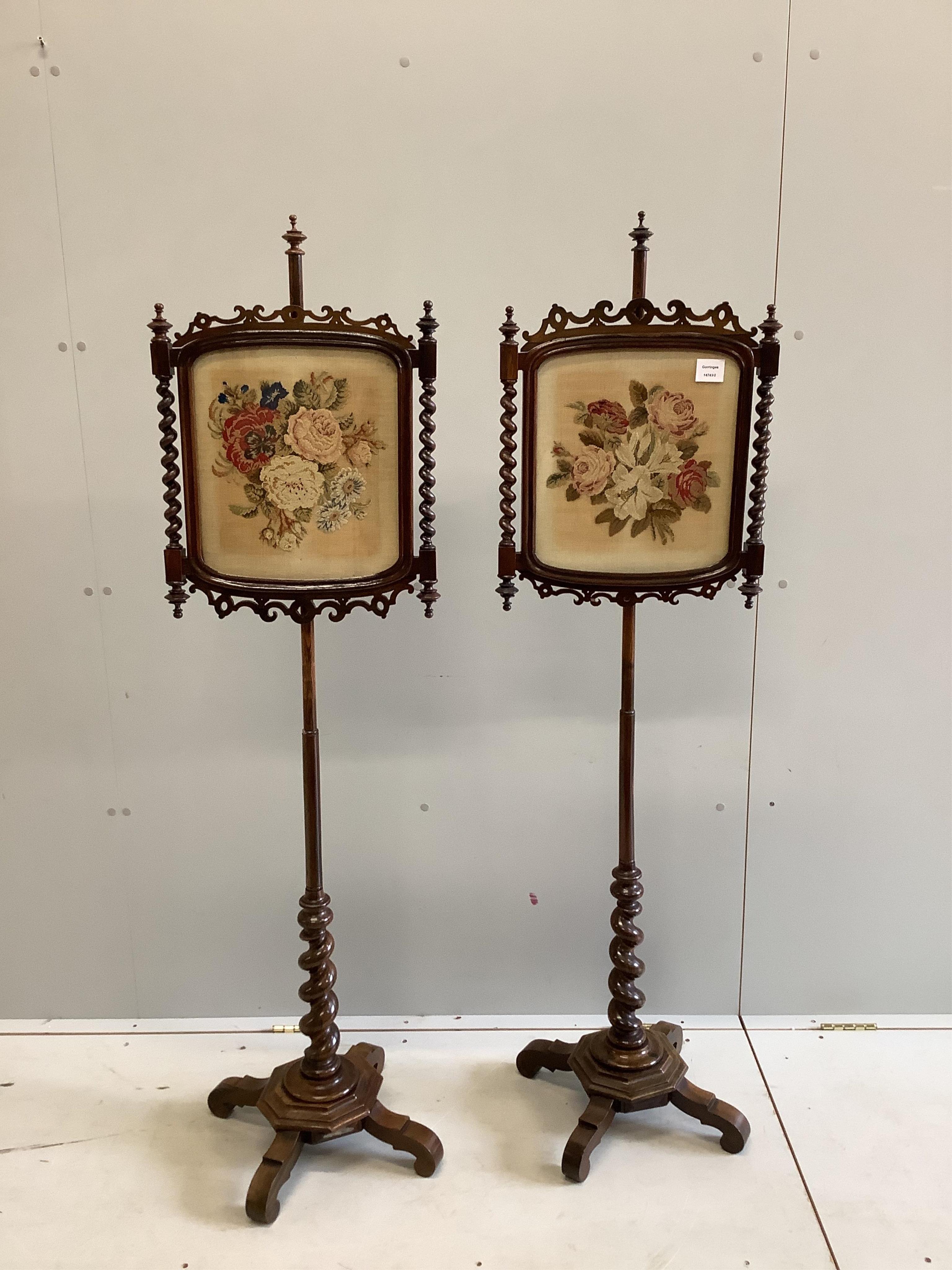 A pair of Victorian rosewood pole screens with floral tapestry banners, height 150cm. Condition - fair